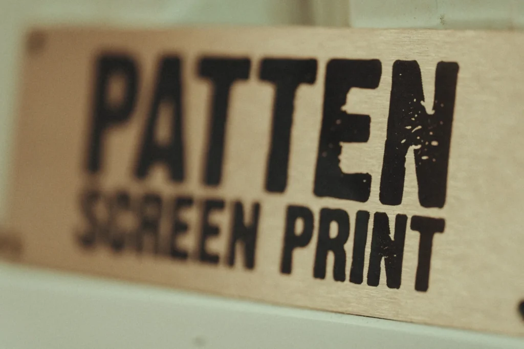 A close-up of the Patten Screen Print sign at Jammy Threads screen printing studio.