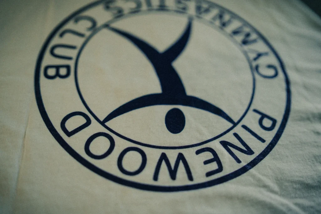 Navy blue Pinewood Gymnastics Club logo printed on custom fabric by Jammy Threads.